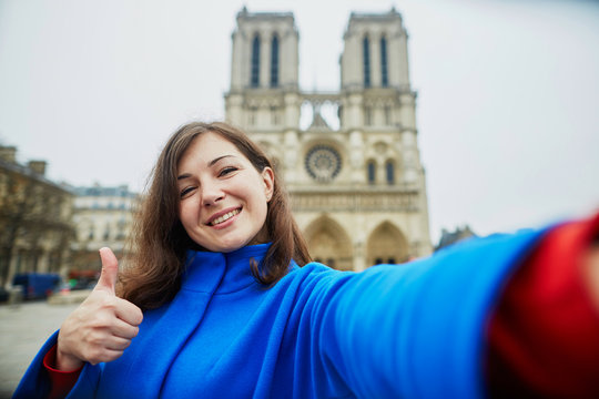 Beautiful young tourist in Paris, making funny selfie