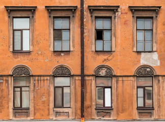 Several windows in a row on facade of urban apartment building front view, St. Petersburg, Russia.