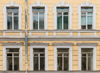 Several windows in a row on facade of urban apartment building front view, St. Petersburg, Russia.