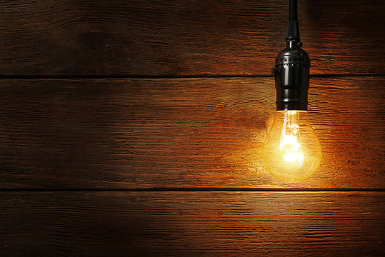 Light bulb on wooden background, close up