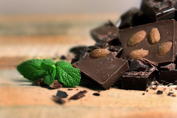 Chocolate pieces with mint leaves on wooden background