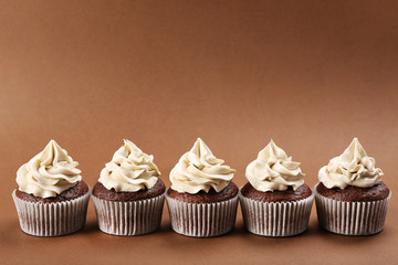 Tasty cupcakes on color background