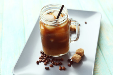 Glass jar of iced coffee on tray