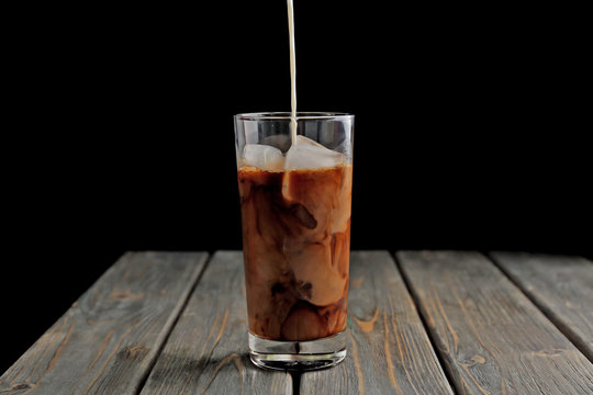 Glass of iced coffee on wooden table