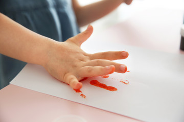 Child making hand print on paper