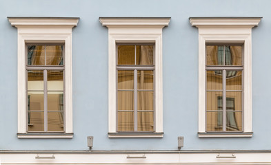 Three windows in a row on facade of urban office building front view, St. Petersburg, Russia.