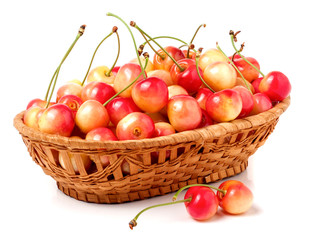 yellow cherries in a wicker basket isolated on white background