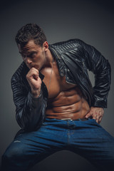 Athletic male model in a jeans and leather jacket.