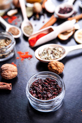 Spices on black background in special jars. Food