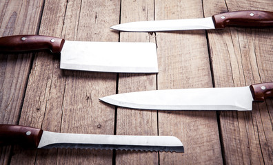 Beautiful knives with wooden handle, on an old table. Kitchen, c