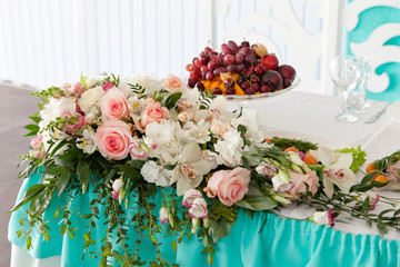  декоррация из живых цветов и ваза с фруктами на столе