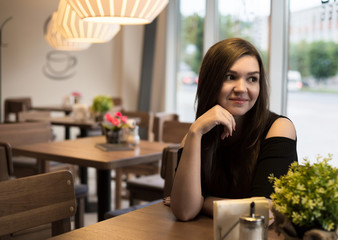 The girl at the table in a cafe