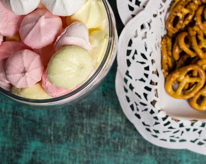 Glass jar with homemade sweet marhmellows, cookies in tablecloth