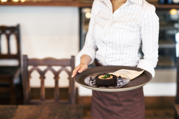 スイーツを持つカフェ店員