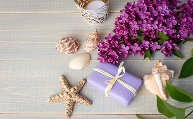 Organic spa soaps with lilac flowers on white wood table. Empty space for text.