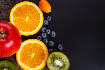 Fresh fruits oranges, kiwi, kumquats, blueberry, apples arranged in a group, natural still life for healthy food. Top view. Empty space for text.