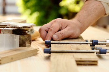 Carpenter hands at work with clamp