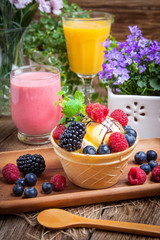 Tasty ice cream dessert with fruit in a waffle bowl.