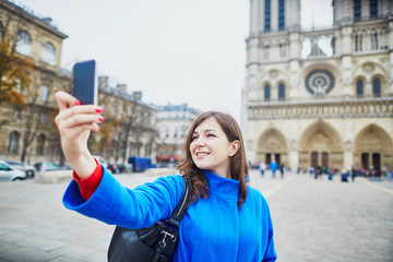 Beautiful young tourist in Paris, making funny selfie