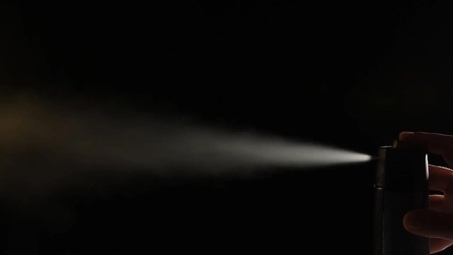 spray deodorant on black background