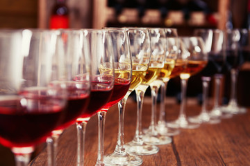 Many glasses of different wine in a row on bar counter