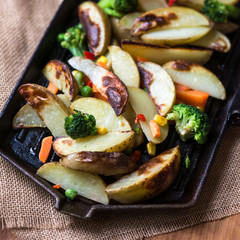 Potato Wedges with Vegetables on Iron Cast Pan