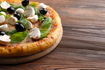 Delicious tasty pizza with ingredients on wooden table