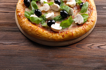 Delicious tasty pizza with ingredients on wooden table