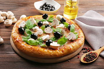 Delicious tasty pizza with ingredients on wooden table