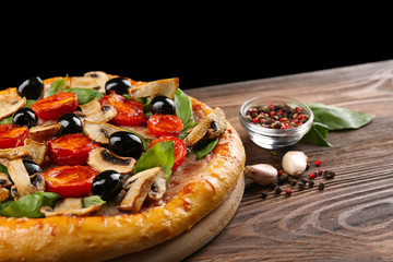 Delicious tasty pizza with ingredients on wooden table