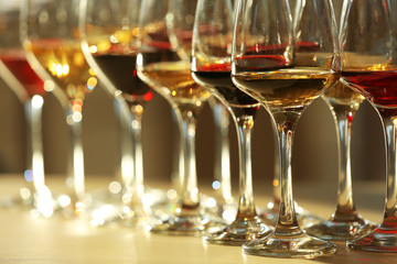 Many glasses of different wine in a row on a table