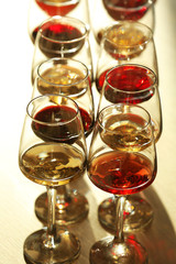 Many glasses of different wine in a row on a table