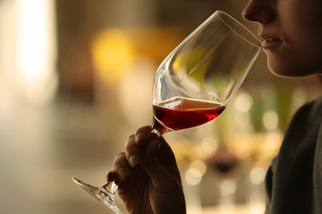 Woman sniffing red wine in a glass, close up