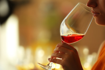 Woman sniffing red wine in a glass, close up