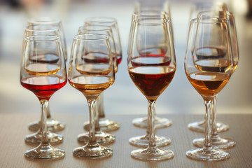 Many glasses of different wine in a row on a table