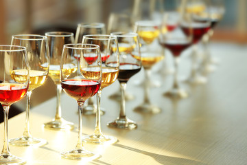 Many glasses of different wine in a row on a table