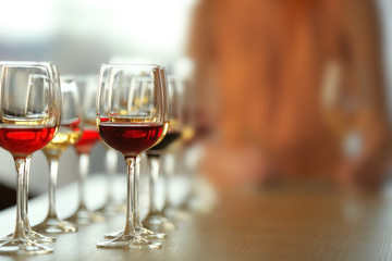 Many glasses of different wine in a row on a table. Tasting wine concept