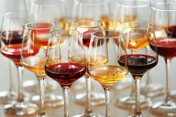 Many glasses of different wine on a table, close up