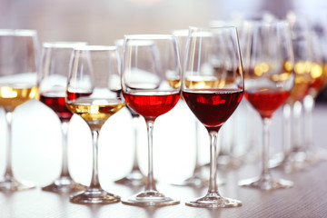 Many glasses of different wine on a table, close up