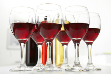 Glasses of red wine on white table closeup