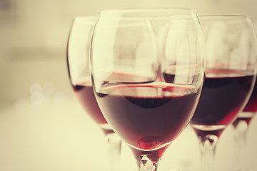 Glasses of red wine on white table closeup