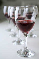Glasses of red wine on white table closeup