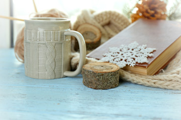 Beautiful winter composition on windowsill with cup of hot drink