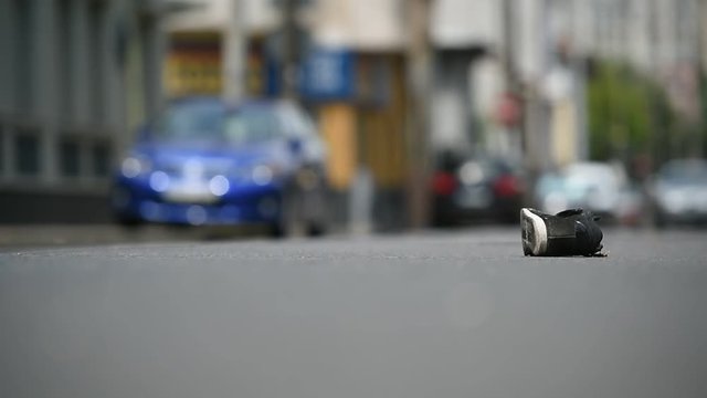 Shoe on the street with cars in background after victim was hit by vehicle