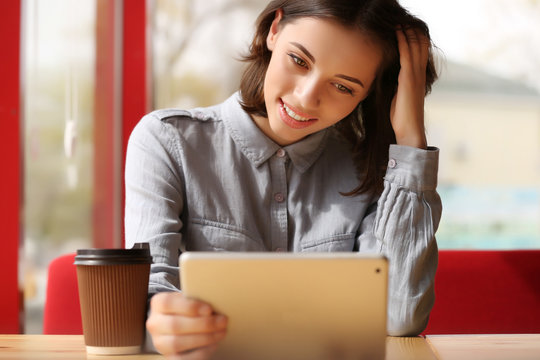 Young woman with tablet sitting in cafe