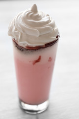 Delicious strawberry milkshake on wooden table