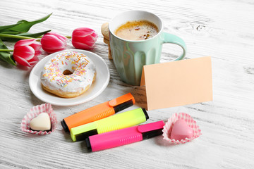 Cup of fresh coffee and note on wooden background