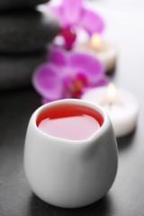 Beautiful spa set with massage oil and orchid on the table, close up