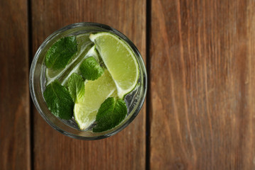 Fresh cocktail with soda, lime on a wooden background