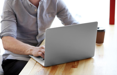 Businessman working with laptop in cafe